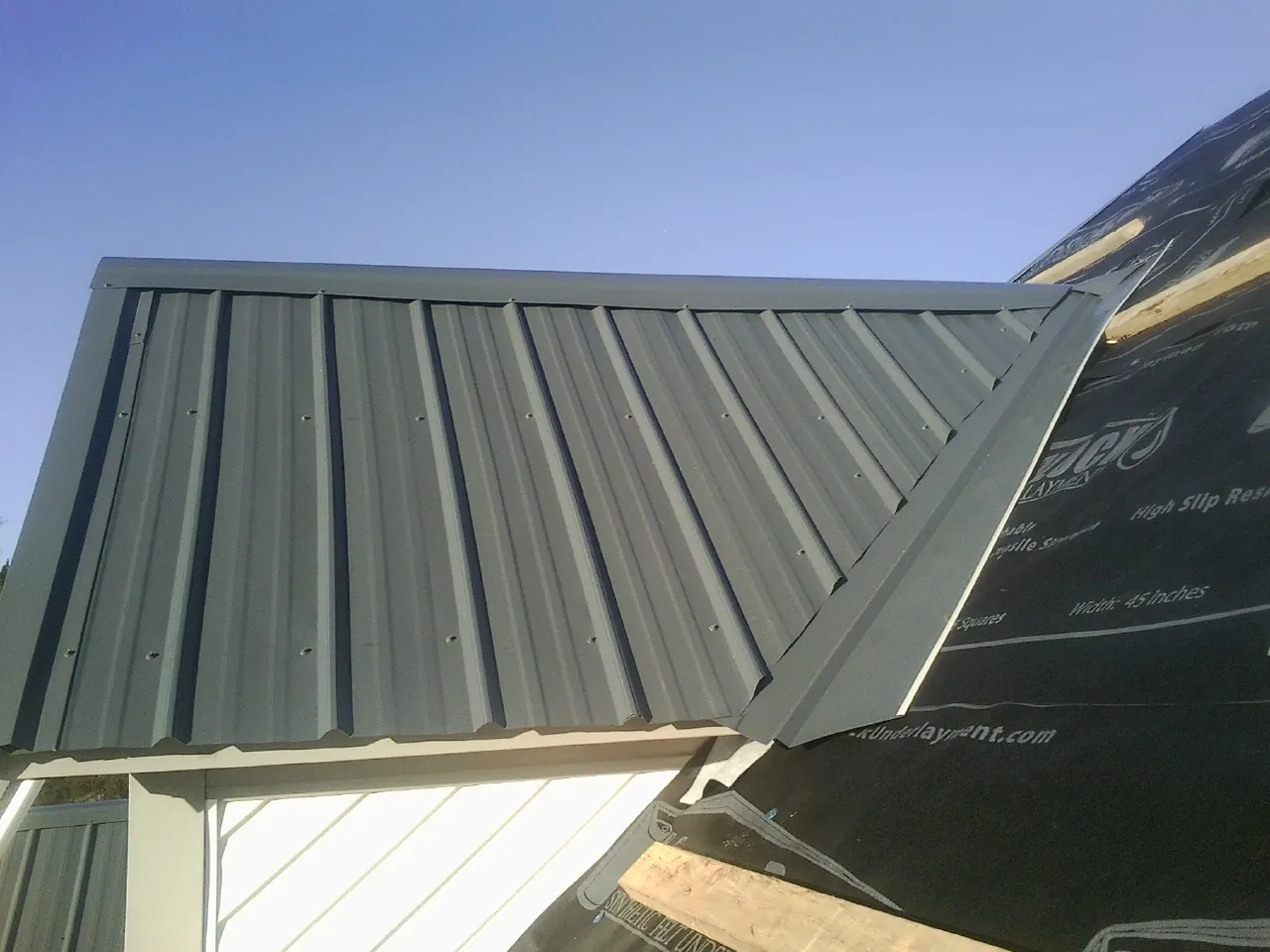 Gray metal roof panels going on over a garage gable in West Lafayette