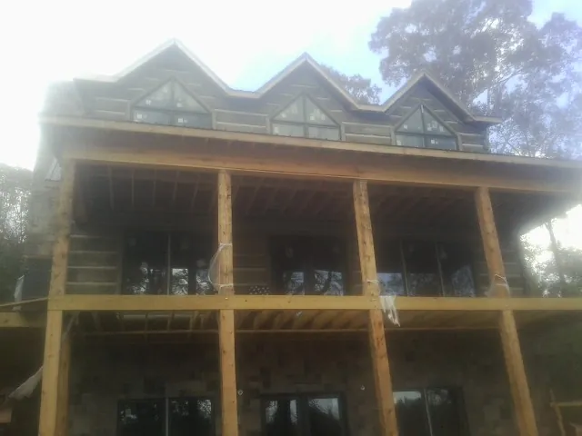 Dormers and porch framing on a large log home under construction — Roof Coating work by our crew in West Lafayette