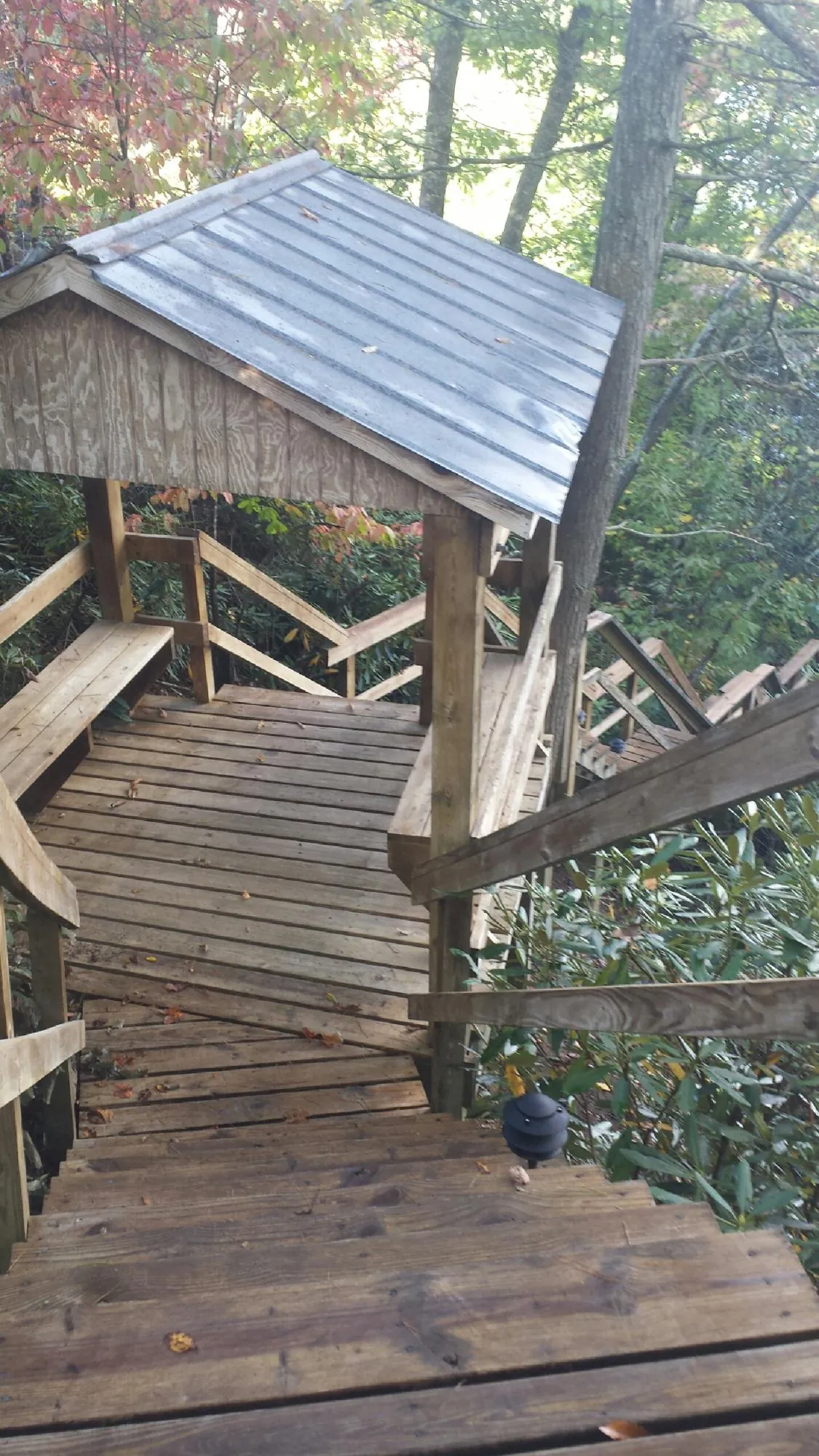 Metal roofed shelter over wooden steps on a wooded walkway — Skylight Repair & Installation work by our crew in West Lafayette