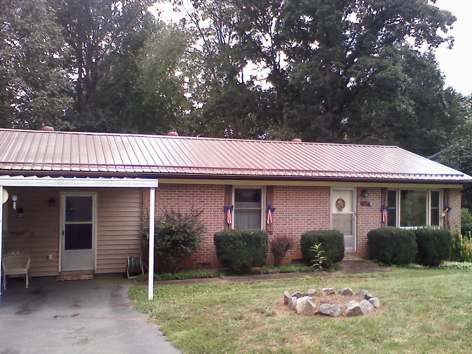 Bronze metal roof and carport on a brick ranch home — Roof Repair work by our crew in West Lafayette